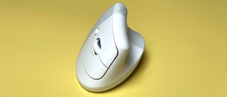 The Logitech Lift for Mac mouse against a yellow background.