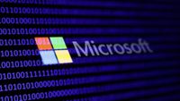 A binary code and Microsoft logo are seen in this multpiple exposure illustration photo.