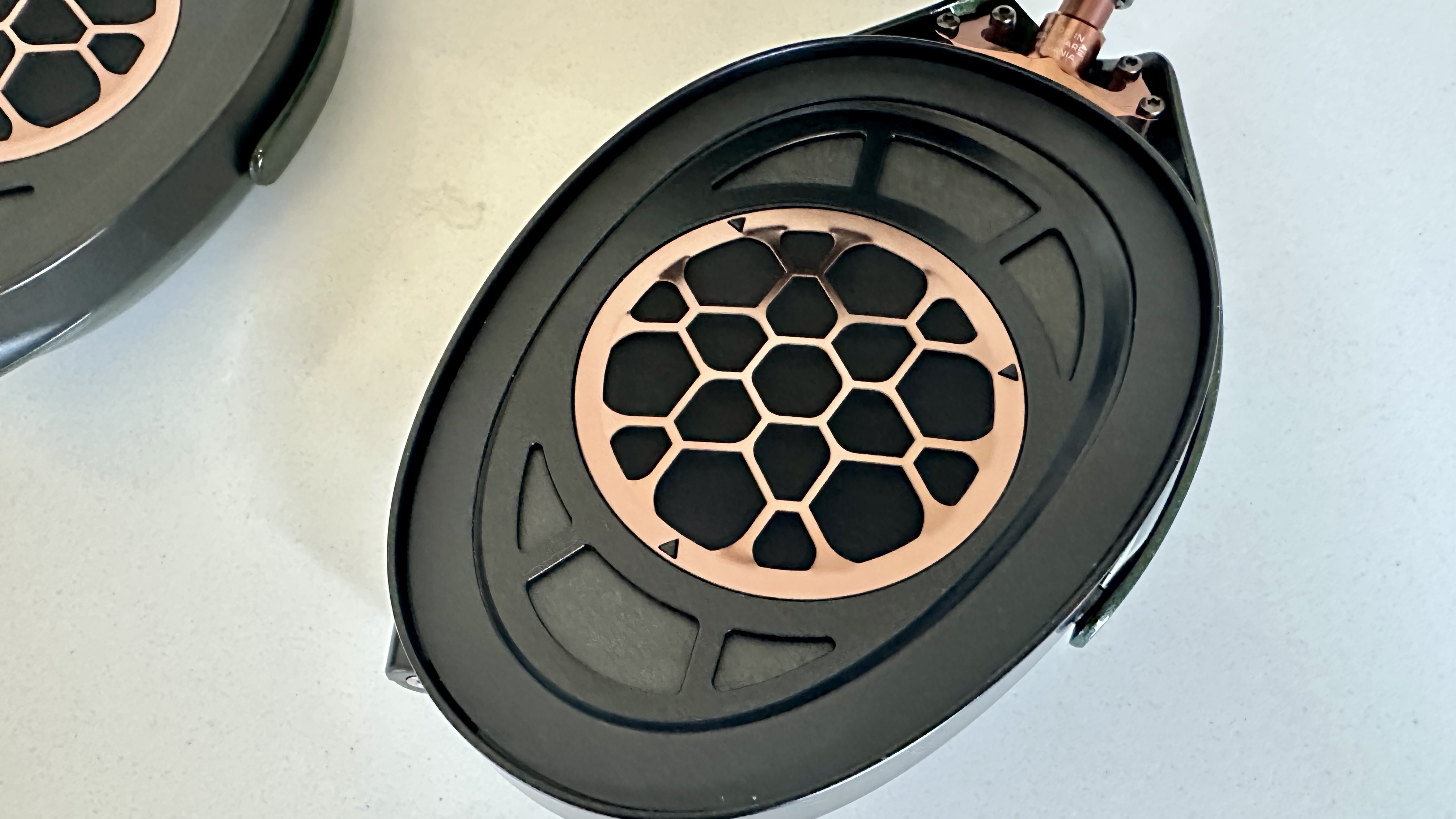 Meze Audio Strada headphones with wooden ear cups, in close-up and with their case and cables visible, on a white table