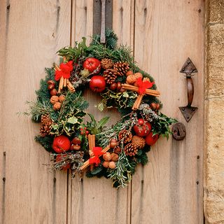 christmas wreath with herbs on wooden door
