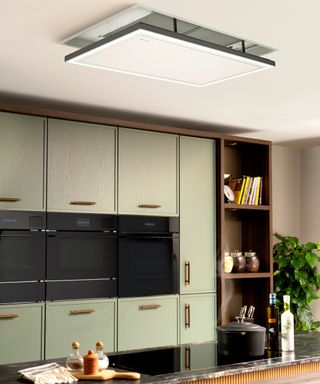 kitchen with green units and white kitchen extractor fan that retracts back into the ceiling when not in use