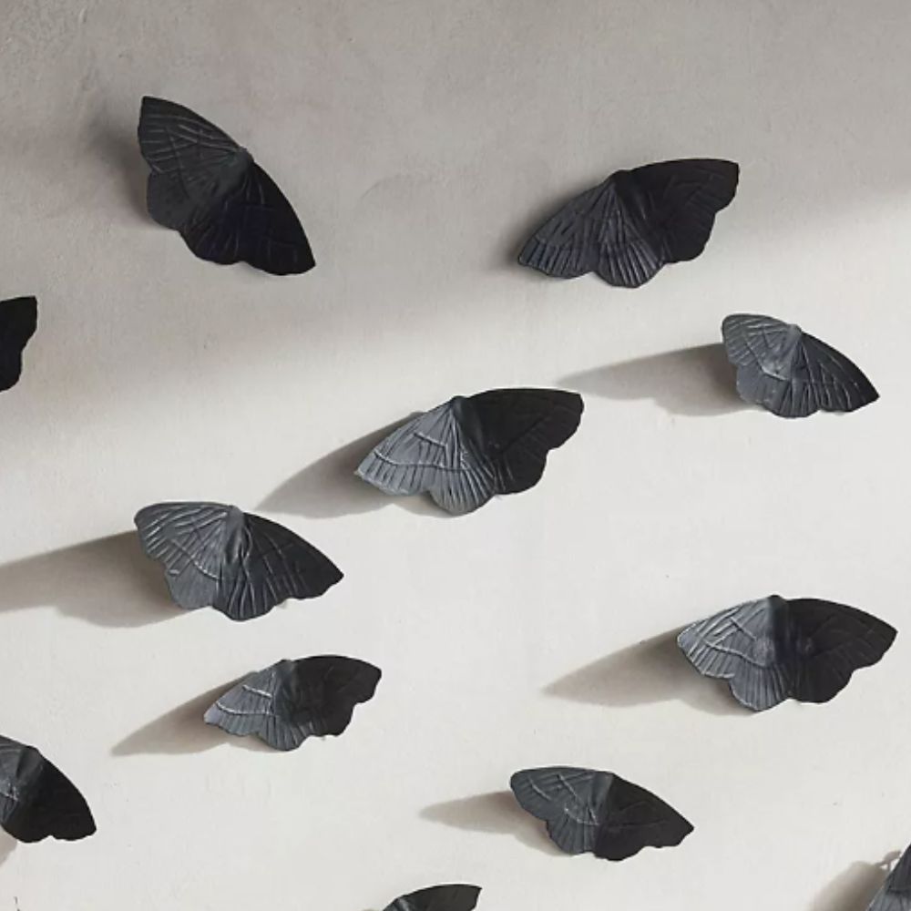 Black iron moth decorations on a white wall