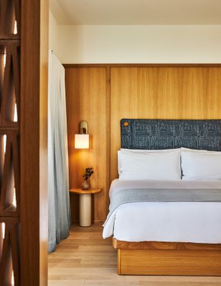 Superior King bedroom at the Alsace hotel with wood panelling and blue fabric headboard