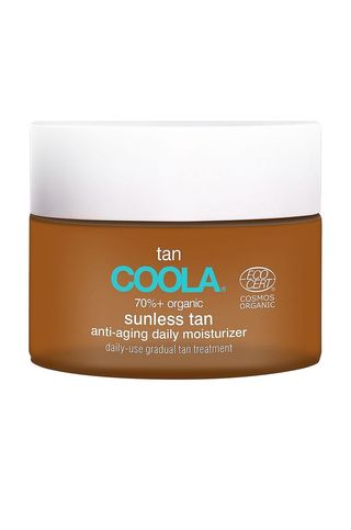 A jar of Coola sunless tan anti-aging daily moisturizer set against a white background.