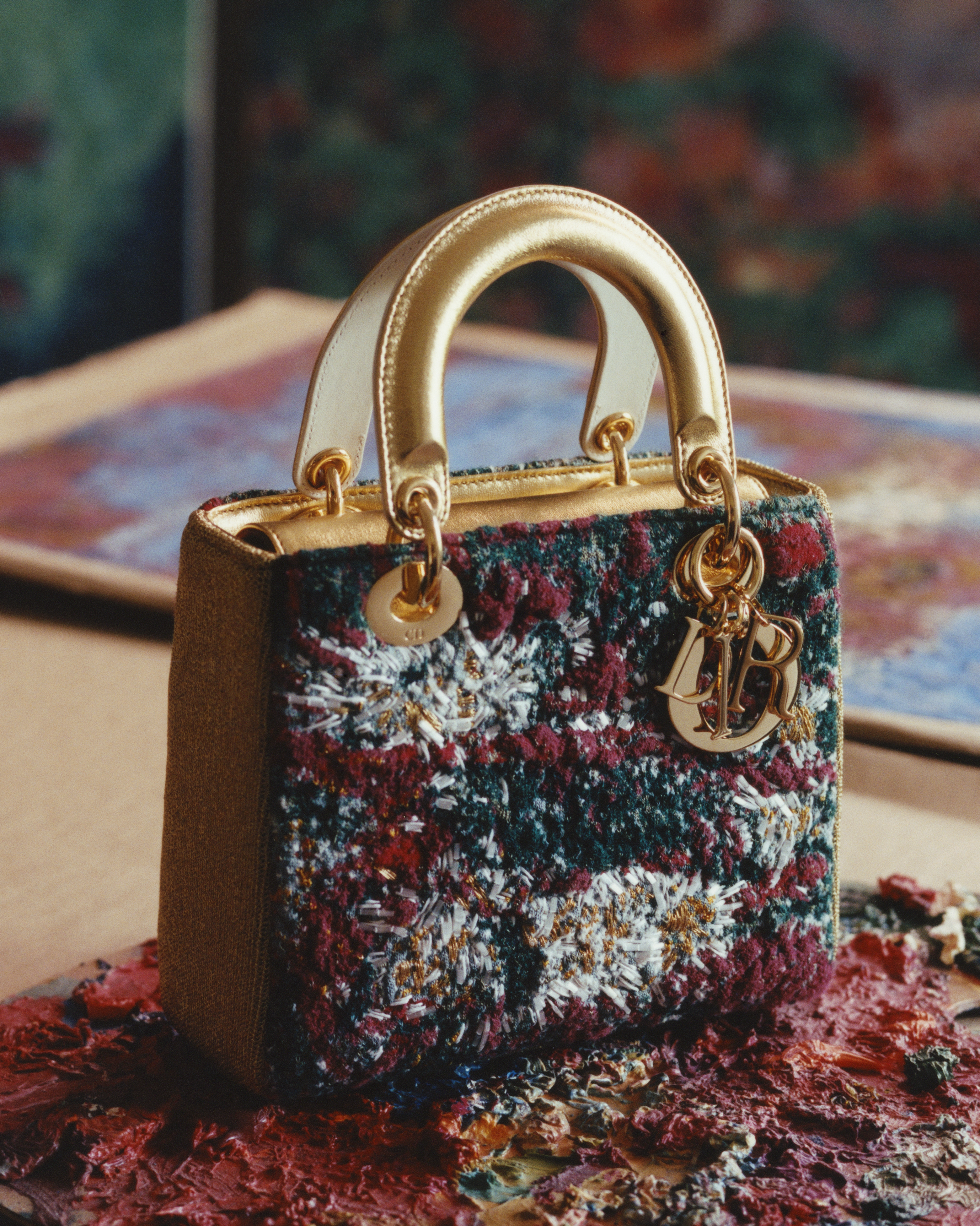 a lady dior art bag with gold handles covered in paint