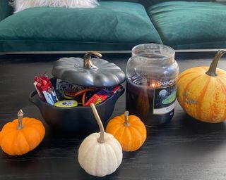 Pumpkin casserole dish from Staub on coffee table with mini pumpkins and candle