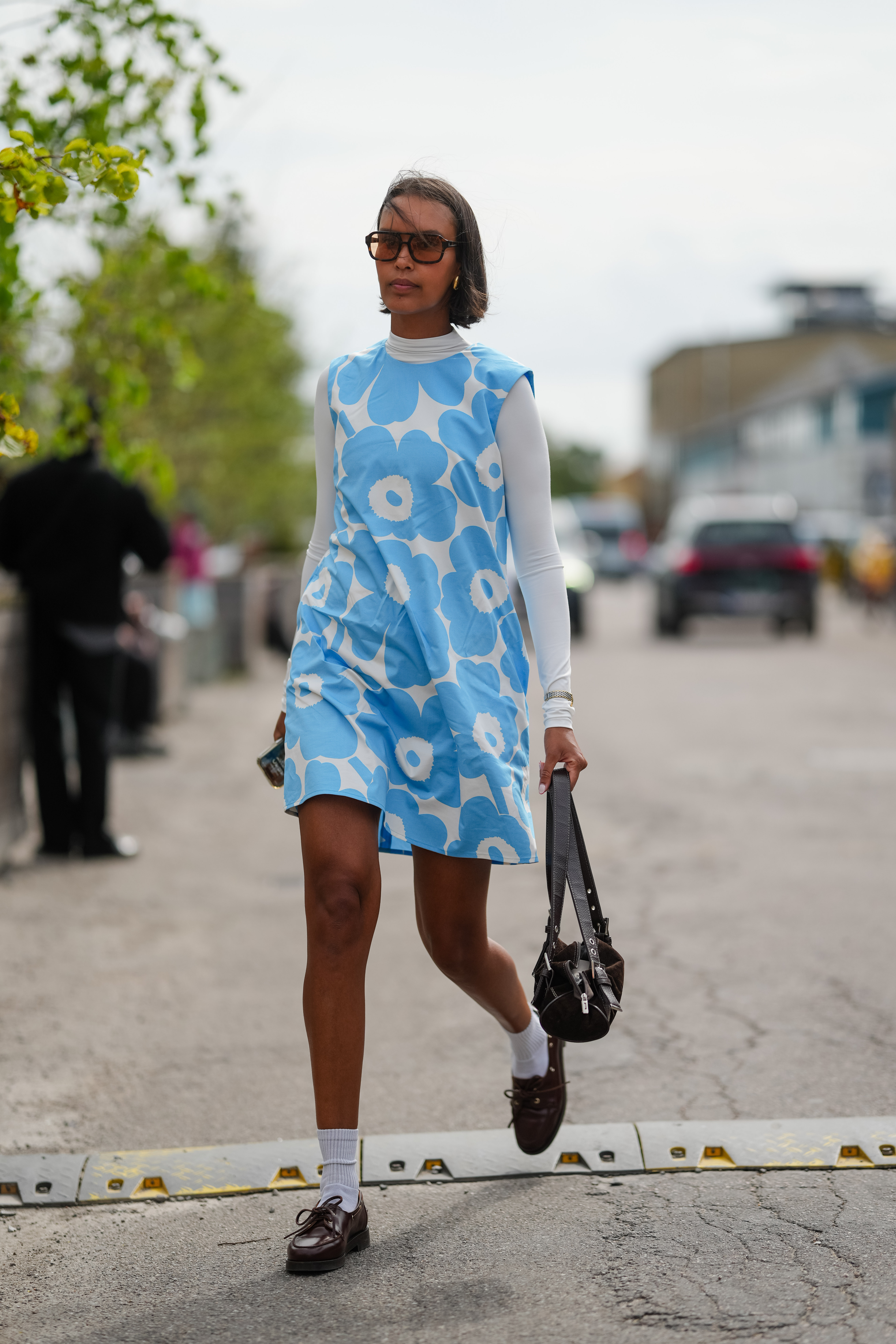 a woman wearing a floral blue shift dress in street style
