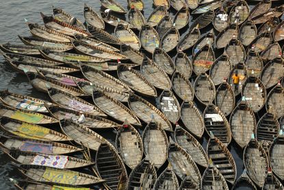 Boatmen wait in the polluted water near the river bank of Buriganga on the eve of World Environment Day, in Dhaka, Bangladesh.