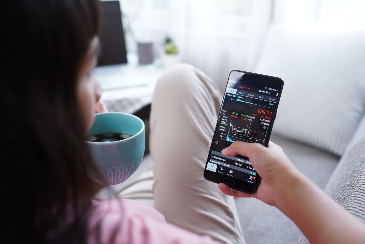 Woman investing online stocks trading on mobile platform app 