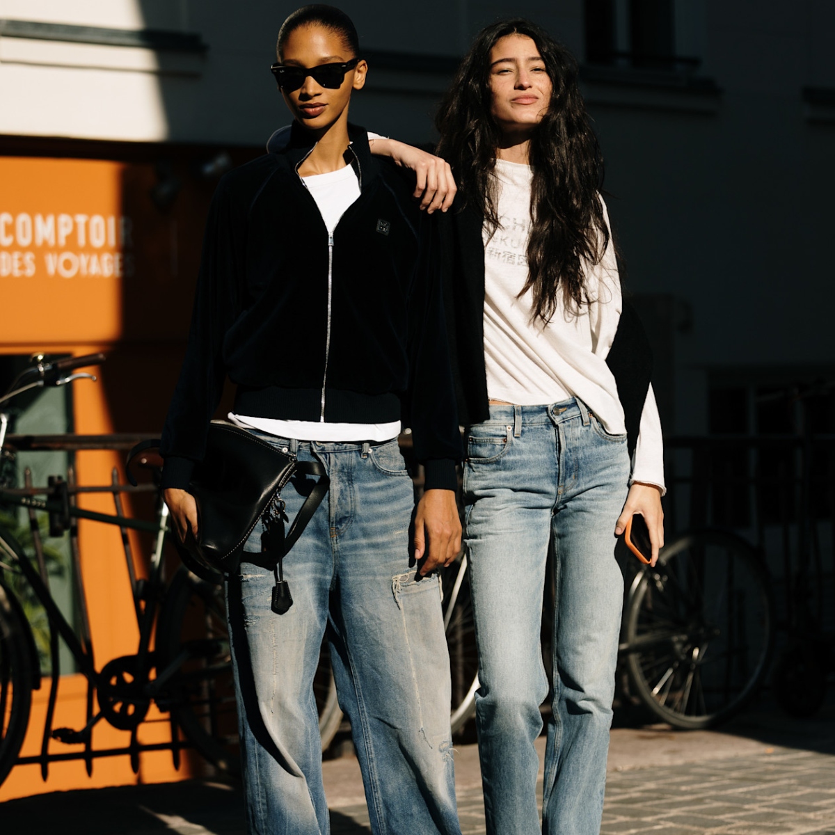 Two off-duty models wearing classic jeans during fashion month street style 