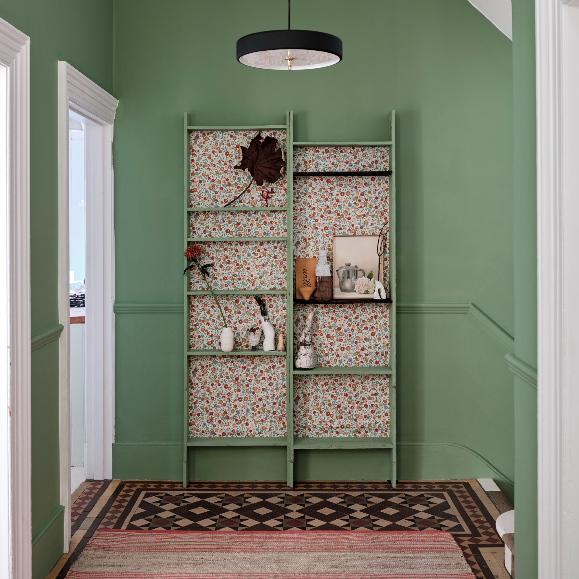 A hallway with a high ceiling painted in Farrow &amp;amp; Ball's Suffield Green with white doors