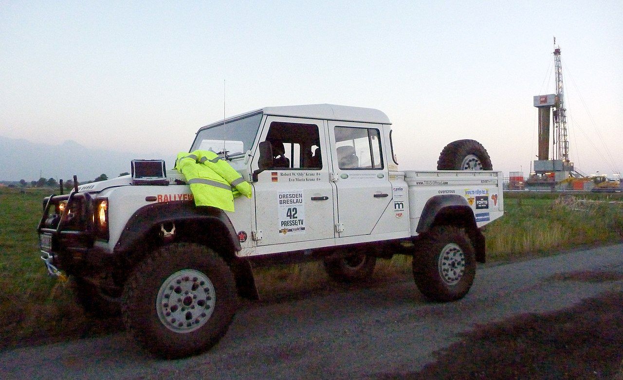 A Panasonic Toughbook on the hood of a Land Rover Defender, with a high-vis jacket next to it.