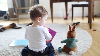 A boy reading a book to his rabbit