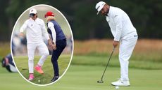 JJ Spaun hits a putt, with Rickie Fowler speaking to a rules official 