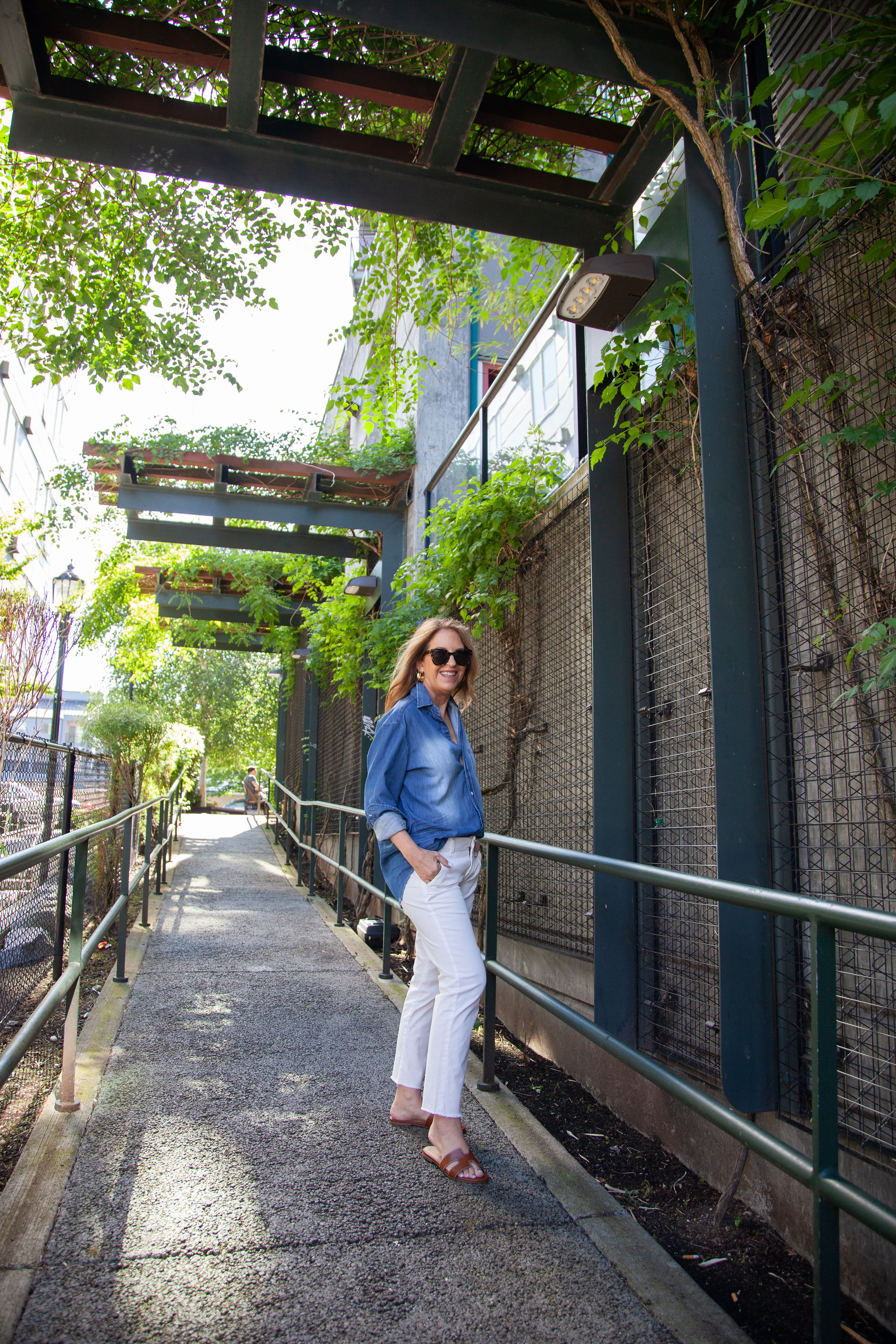 Sandy Koszarek posing in denim shirt and white pants