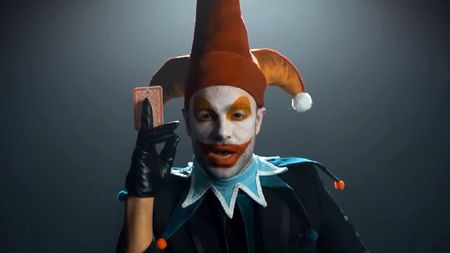 live action Jimbo the Jester from Balatro holding a playing card and addressing the camera