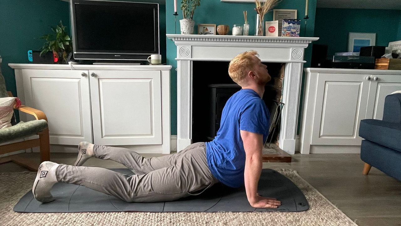 Fit &amp; Well fitness writer Harry Bullmore completing a mobility routine at home