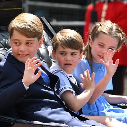 Prince George, Princess Charlotte and Prince Louis wave from a carriage at the Trooping the Colour