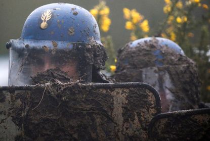 A French gendarme holds his mud-splattered shield during an evacuation operation in the zoned ZAD (Deferred Development Zone) in Notre-Dame-des-Landes, near Nantes, France