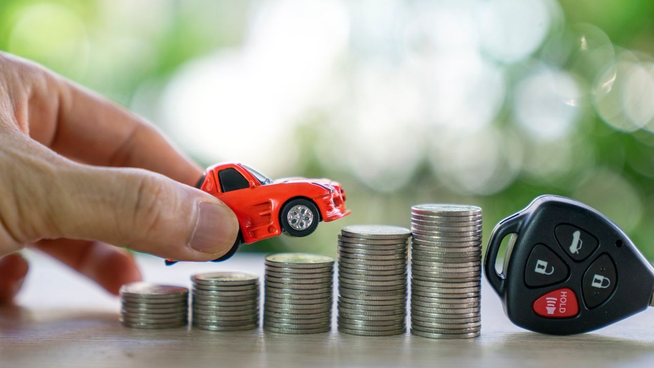 Toy car on piles of coins next to key