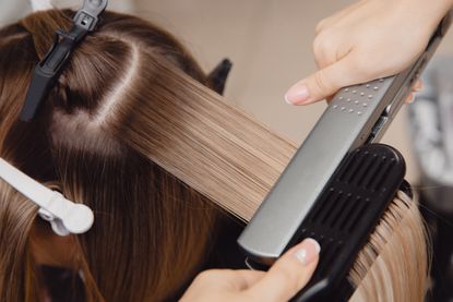Best hair straighteners: brunette hair being straightened