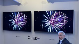 Philips OLED909 and OLED908 TVs side-by-side, with both screens showing bright fireworks
