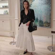 Mariko Nakafuji wearing a waistcoat and white skirt