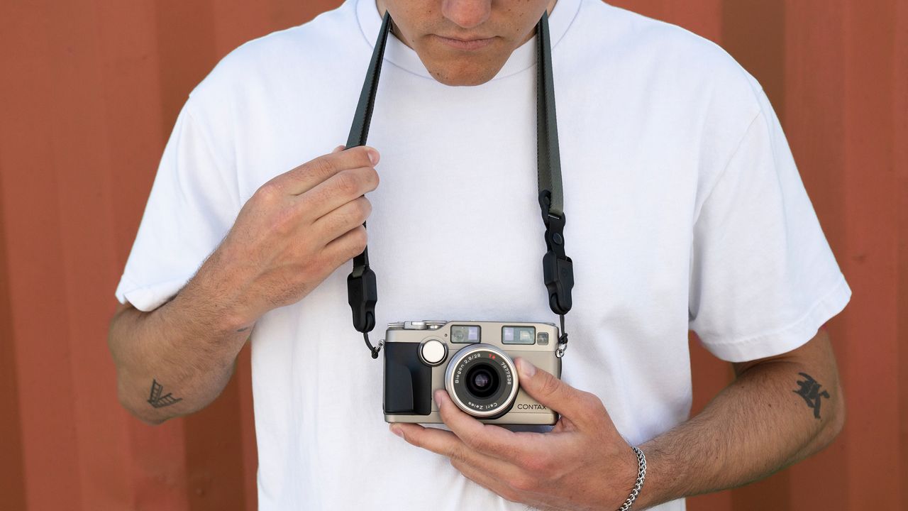 The Wandrd Magnetic Camera strap being used by a photographer