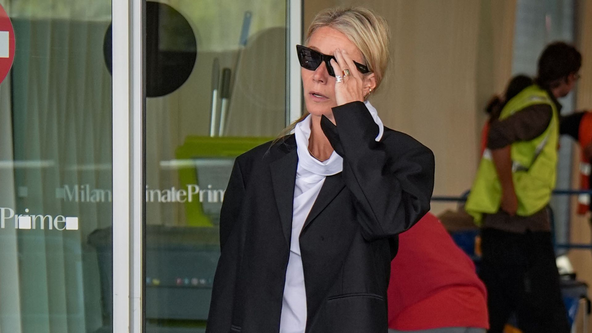 Gwyneth Paltrow steps out at Milan airport wearing loafers with capri pants and a black blazer.