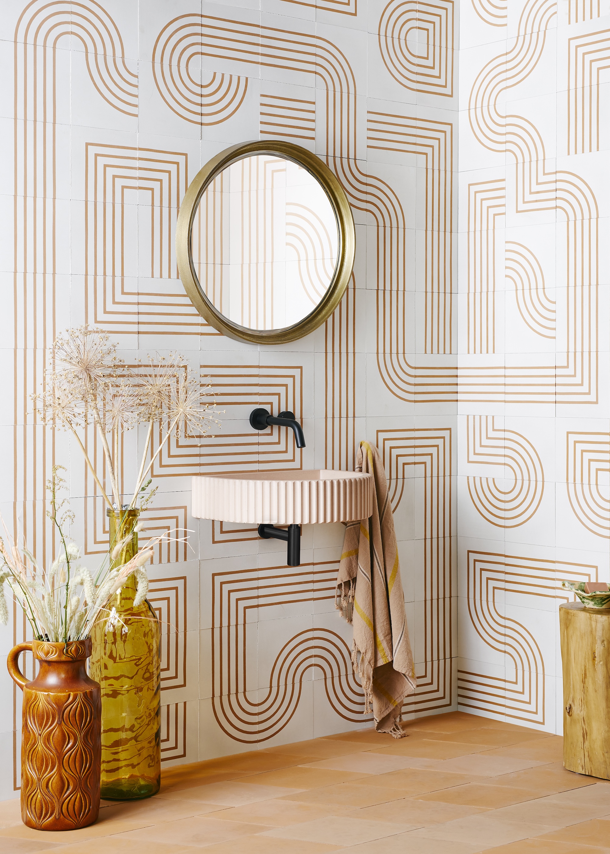 a bathroom with cement tiles with linear patterns on, with a small wall mounted sink and mirror
