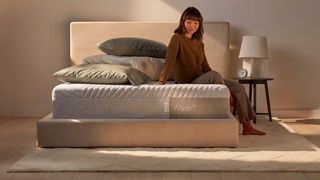 Casper mattress sales, deals and discount code: A woman with dark hair sits on the edge of the Casper Wave mattress