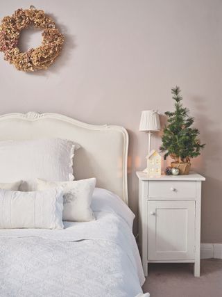 guest bedroom with metallic christmas wreath on wall