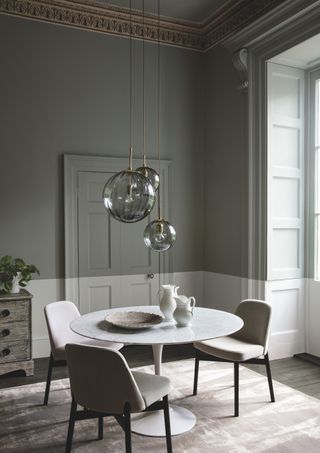 grey dining room with statement lighting by Paint and Paper Library