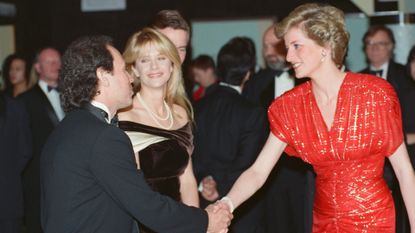 Princess Diana wearing a red dress shaking hands with Billy Crystal as Meg Ryan looks on at the &#039;When Harry Met Sally&#039; premiere