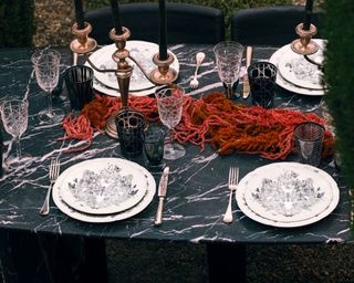 gothic tablescape with white ornate plates and long candles