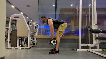 Farzad Aziz doing a deadlift with dumbbells