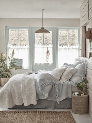 blue and white bedroom with pale blue bedding, blue woodwork on window and door