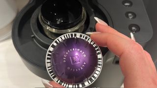 Image showing a Vertuo coffee pod, this one was decaffeinated, being put into the machine