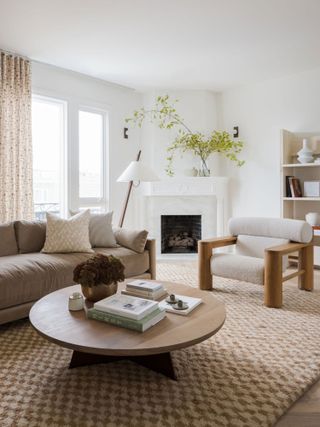White lviing room with beige sofa, round wooden coffee table and brown check rug