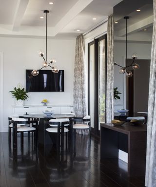 A black and white breakfast dining table and chairs in the corner of a contemporary kitchen