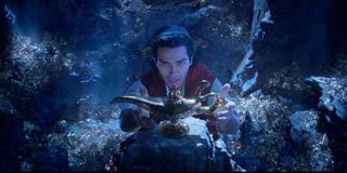 Aladdin pulling the lamp from the cave of wonders