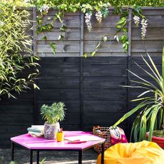 garden area with grey fence and potted plants