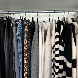 White wardrobe with jumpers and jeans hung up