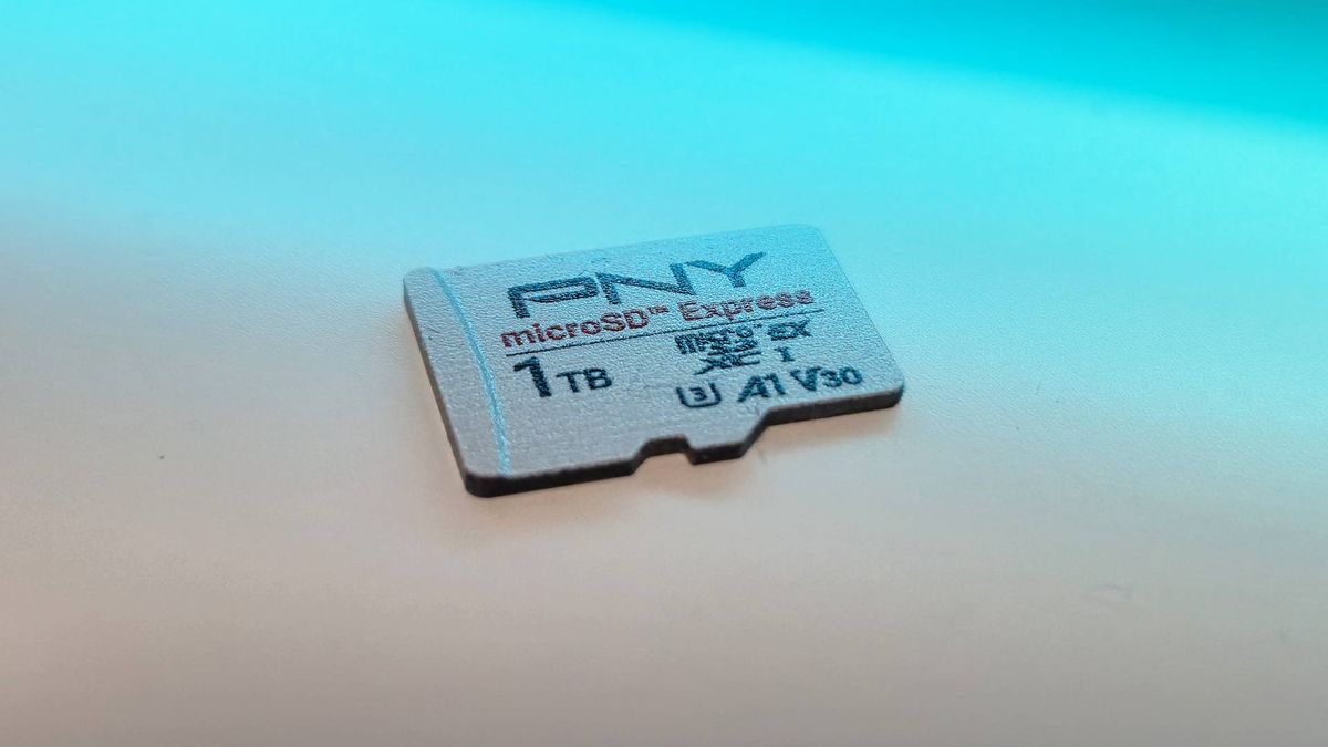 Image of the 1TB PNY microSD Express card sitting on a white desk with blue RGB lighting.
