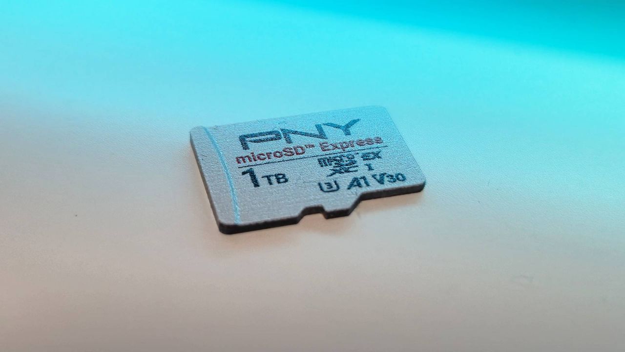 Image of the 1TB PNY microSD Express card sitting on a white desk with blue RGB lighting.