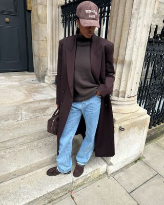 woman in long brown wool coat, turtleneck, and jeans