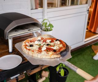 Putting a pizza into a pizza oven.