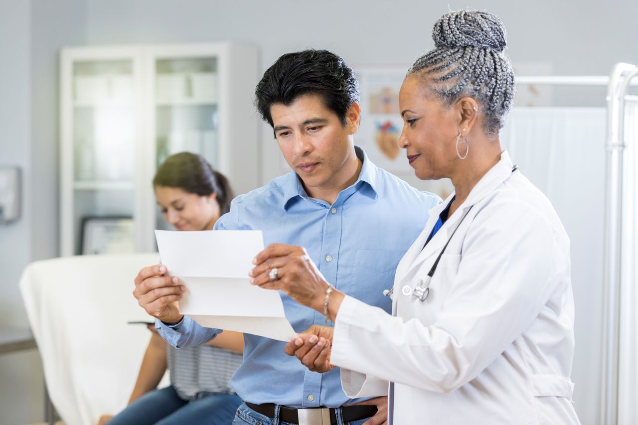 A doctor discussing a document with a patient.