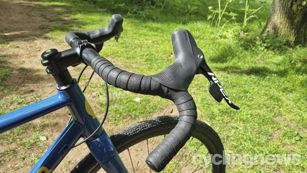 A close up of the wide handlebars of a blue Sonder Camino gravel bike