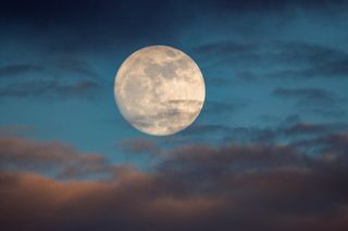 A photo of a nearly full moon. The image was taken one day prior to the supermoon, or a moon that appears larger due to being the closest to Earth in its orbit.